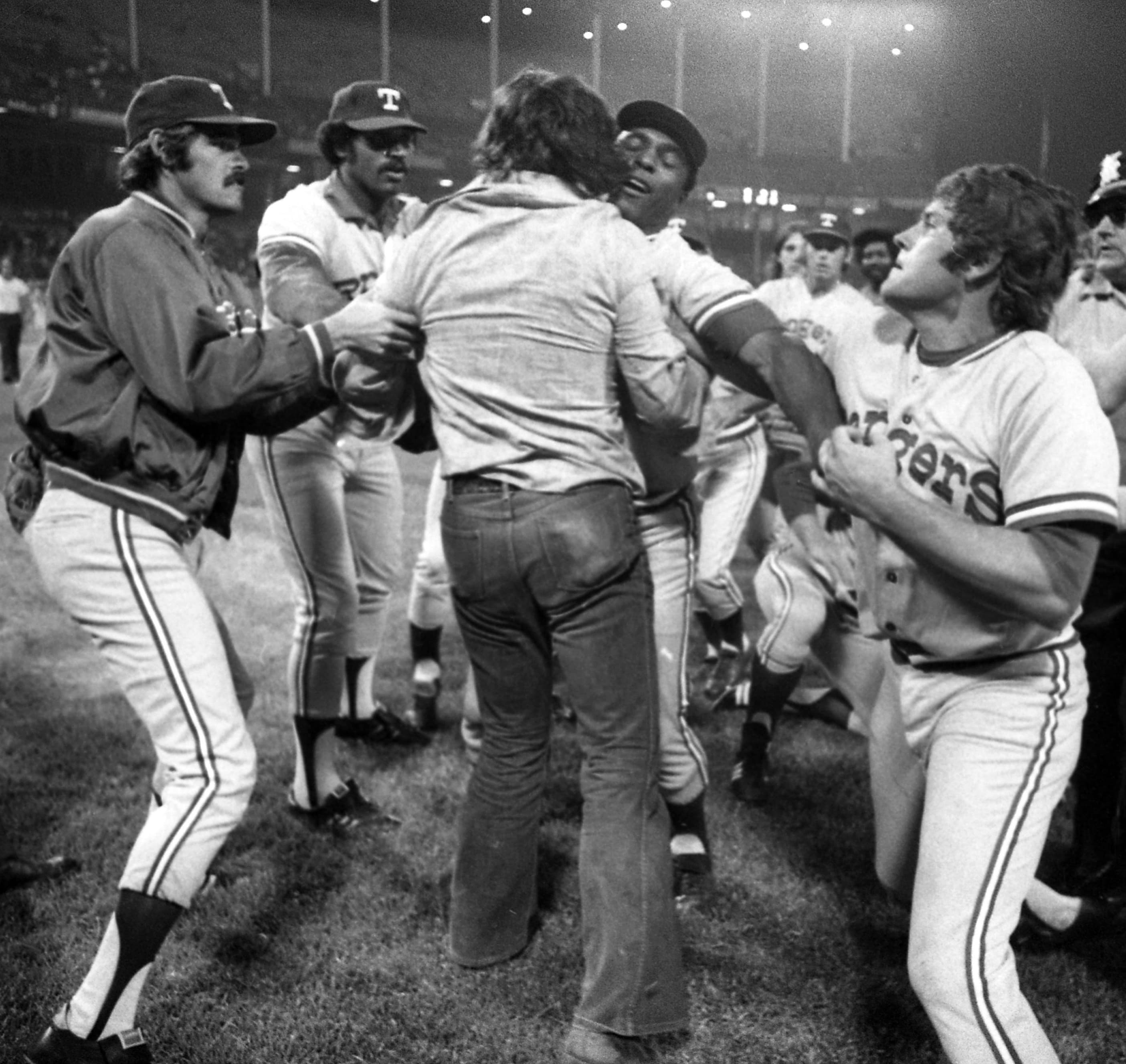 Rangers' Mike Hargrove punches a fan held down by teammate Alex Johnson during Ten-Cent Beer Night at Cleveland Stadium, June 4, 1974.